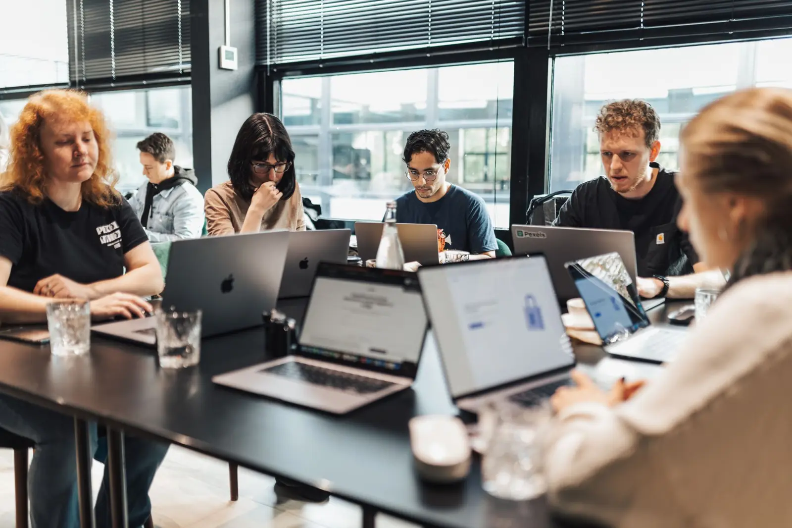 Collega's werken samen aan laptops tijdens een training